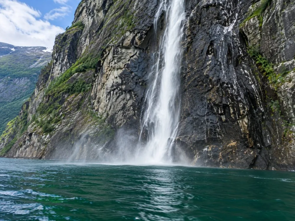 An electric catamaran on the Lysefjord directly below the cliff of Pulpit Rock