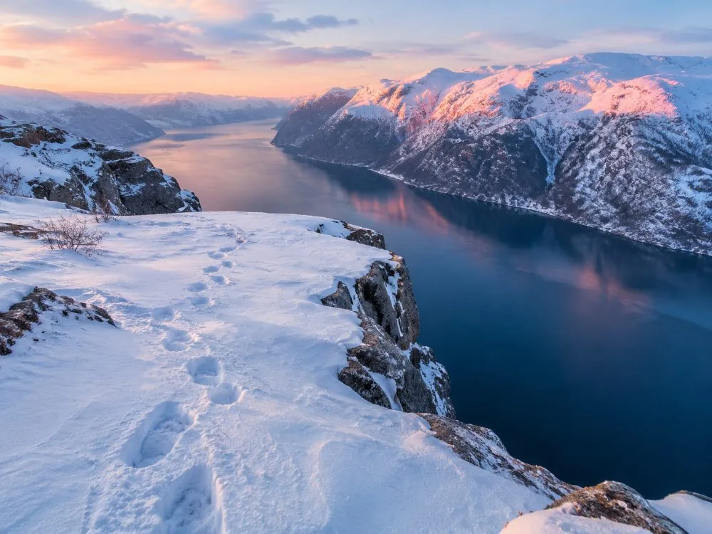 The Preikestolen trail under snow, with a guided group in winter kit and crampons